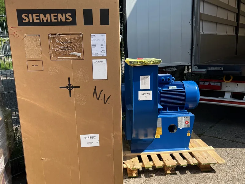 Siemens-Schaltschrank in Holzverschlag und Elektromotor auf Palette vor einem LKW in Berlin